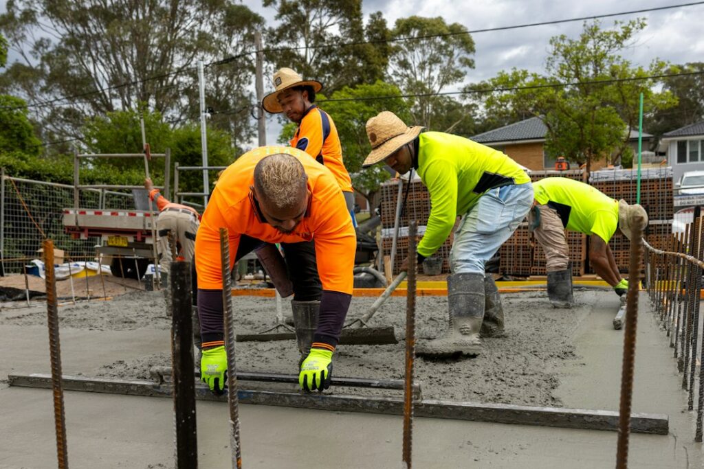 Construction workers pouring and leveling concrete
