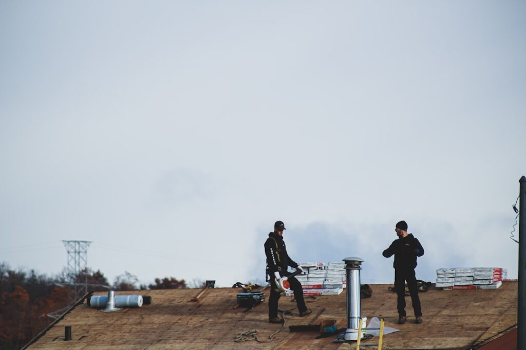 Roofing contractors working on a flat roof - stock photo by Compagnons on Unsplash